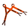 STIHL orange button on chainsaw trouser braces. Visible orange button with STIHL logo, securing black elastic braces.