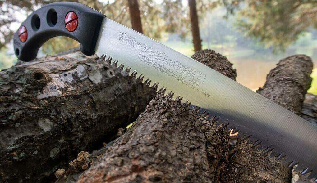 Pole Saws vs. Pruning Saws: What’s Right for Your Job? - close-up of a pruning saw on wooden logs.