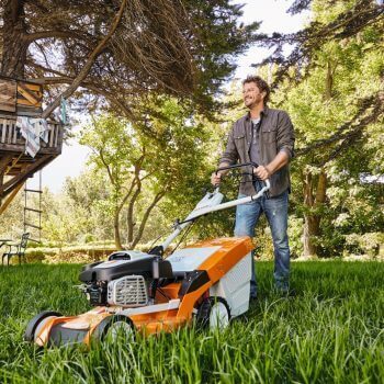 Man mowing grass with a lawn mower, demonstrating lawn care with Lawn Mowing Tips: How to Mow the Grass Properly.