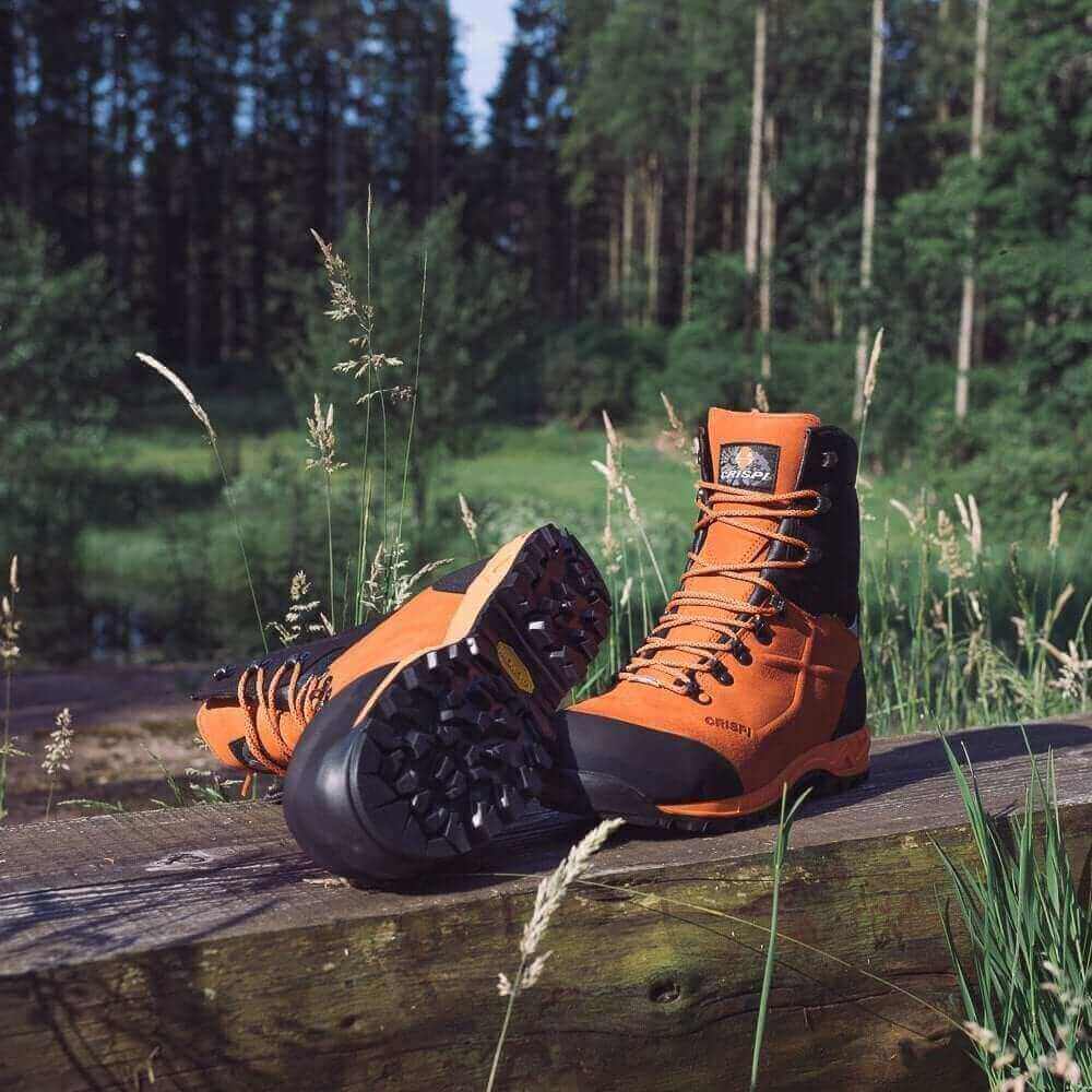 The Ultimate Guide On Which Chainsaw Boots You Need To Buy - orange chainsaw boots on display outdoors.