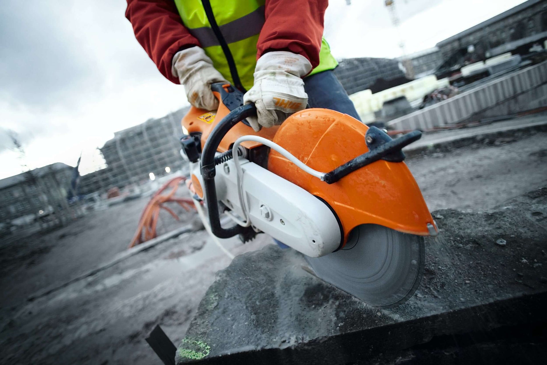 Worker using a STIHL disc cut-off machine on a construction site for precise cutting of concrete.