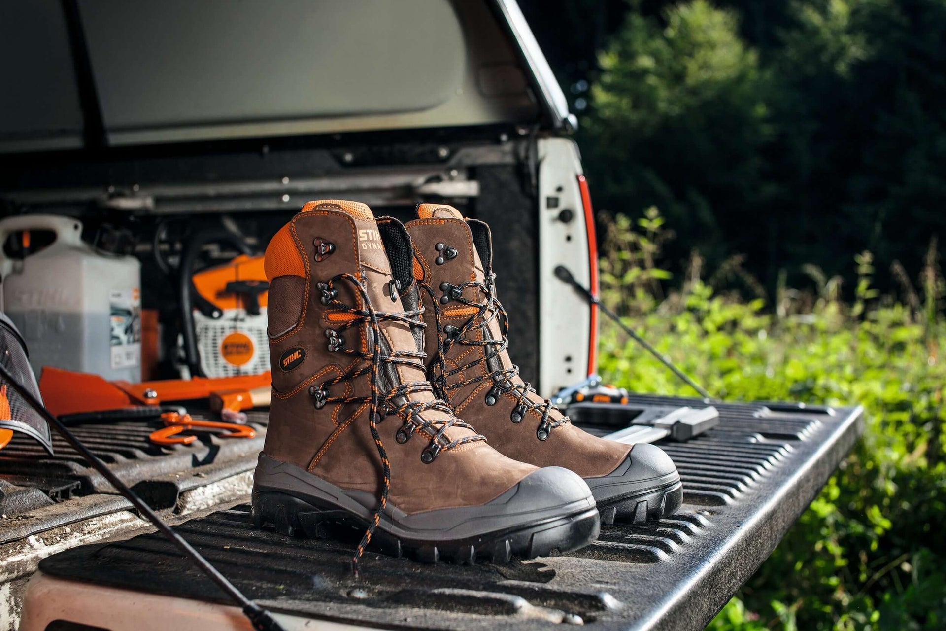 Pair of rugged chainsaw boots on a pickup truck tailgate, perfect for tree surgeons and outdoor safety.