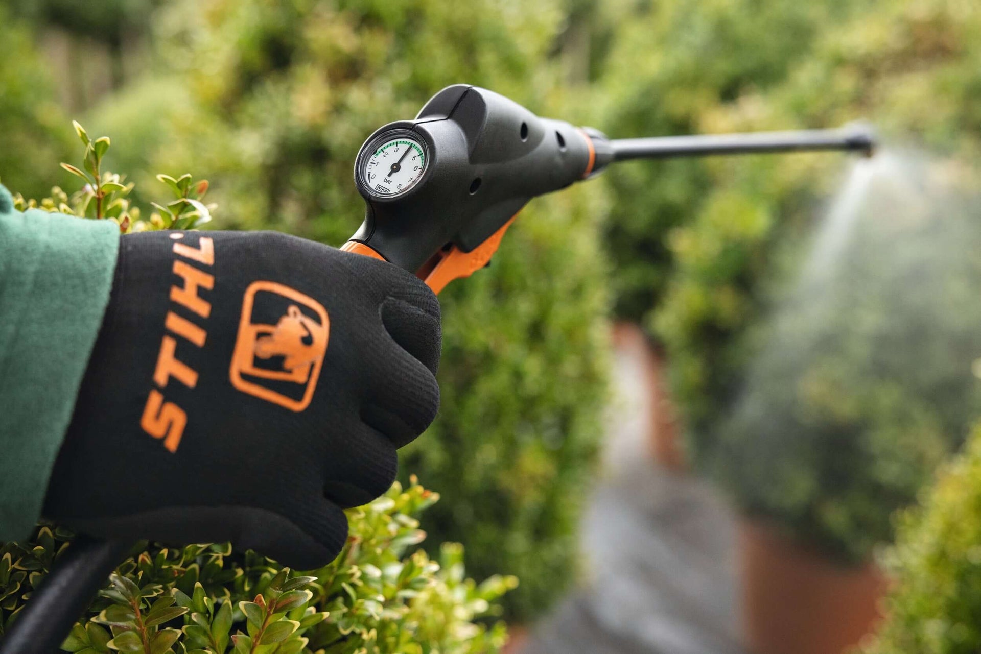 STIHL garden sprayer in use, perfect for tree surgeons and garden maintenance, featuring precision nozzle for targeted application.