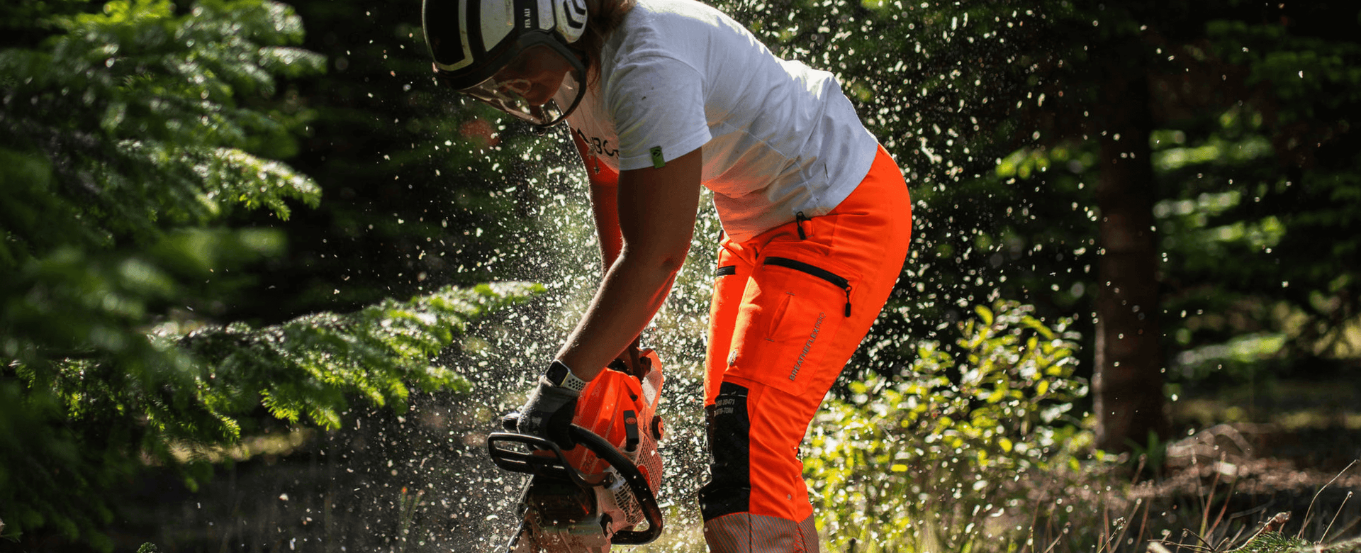 Arbortec Womens Collection showcasing a woman using a chainsaw in protective gear in a forest.