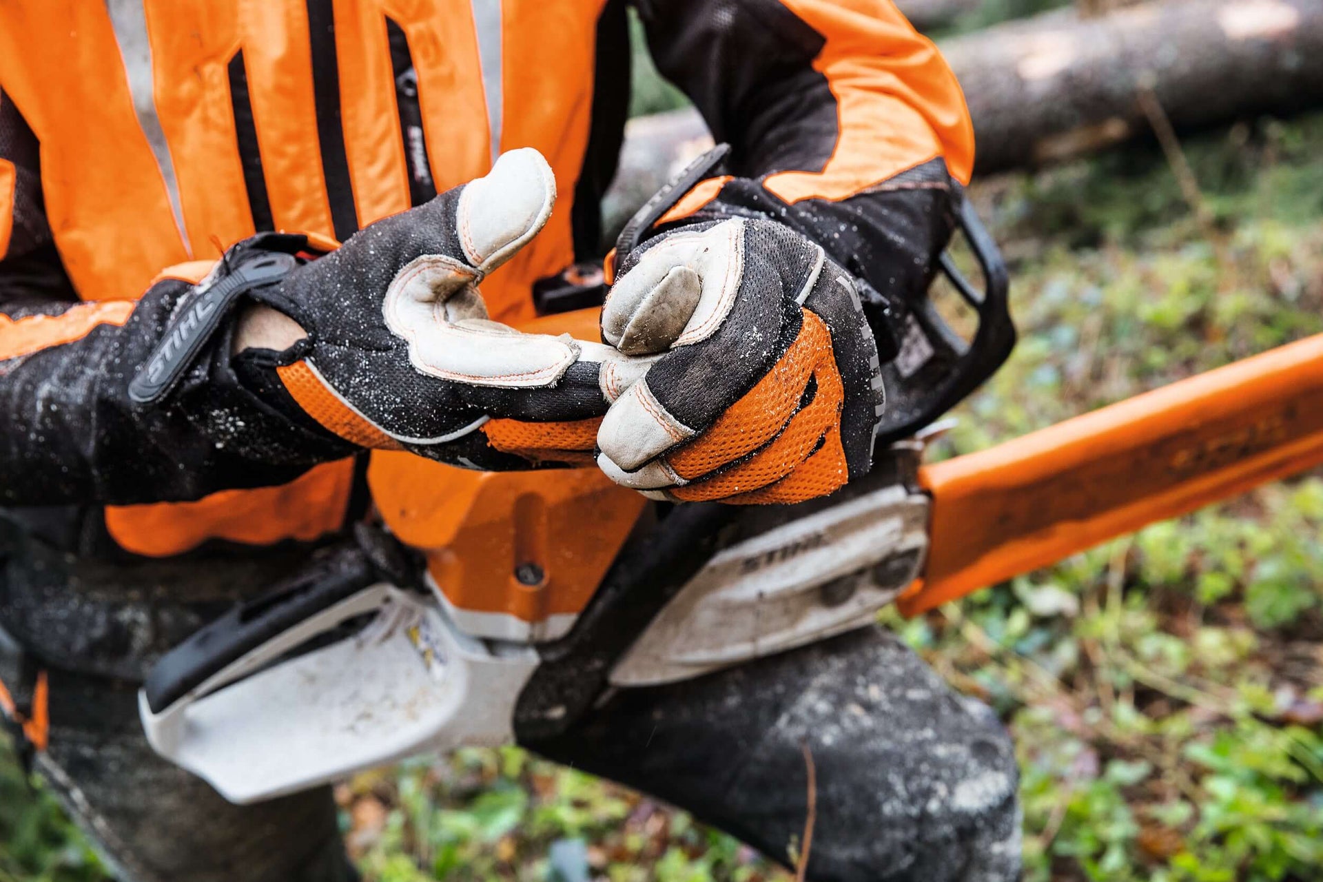Worker wearing cut-resistant chainsaw gloves, highlighting safety for tree surgeons and forestry tasks.