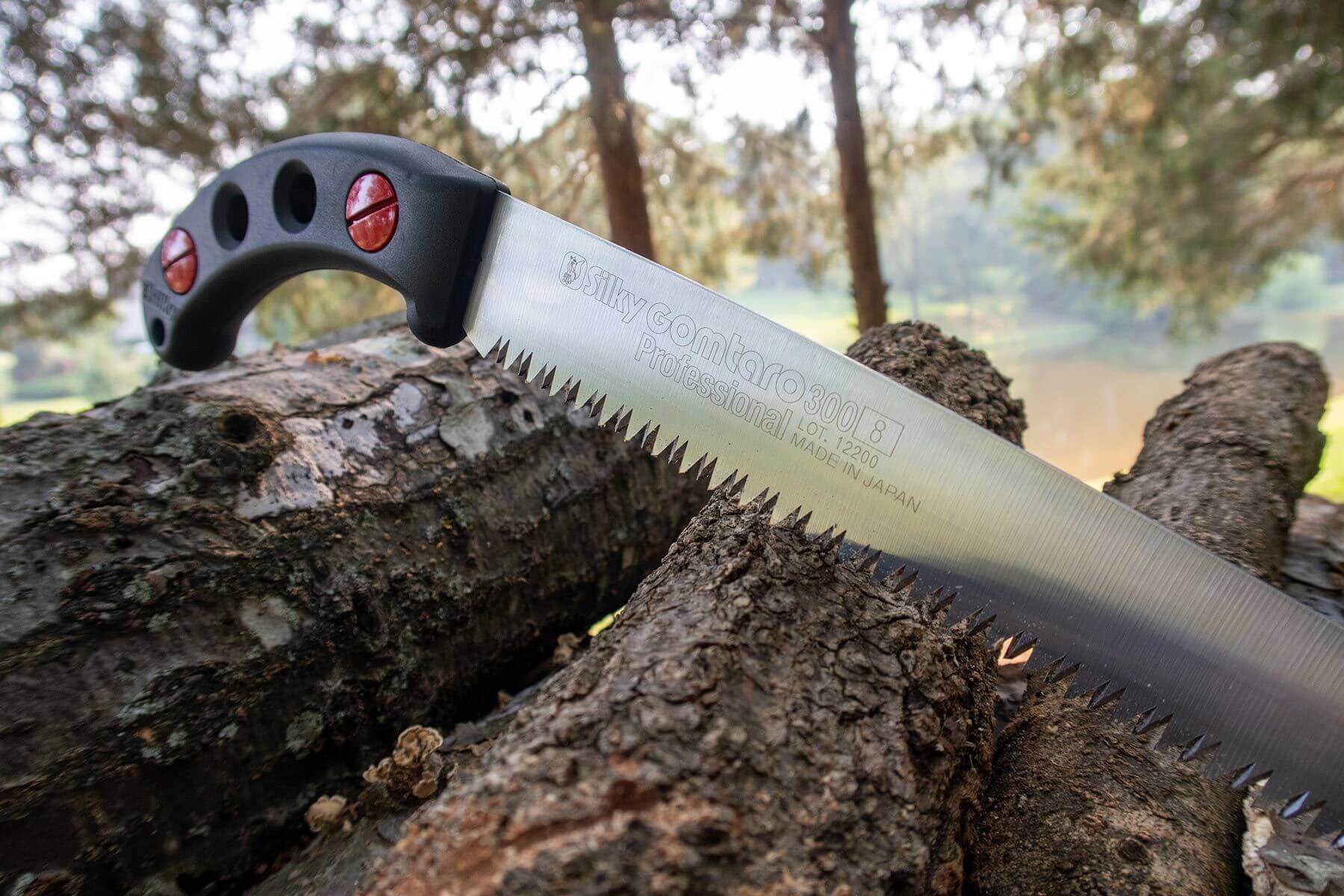 Silky saw resting on logs, showcasing precision engineering for tree surgeons and expert gardeners.
