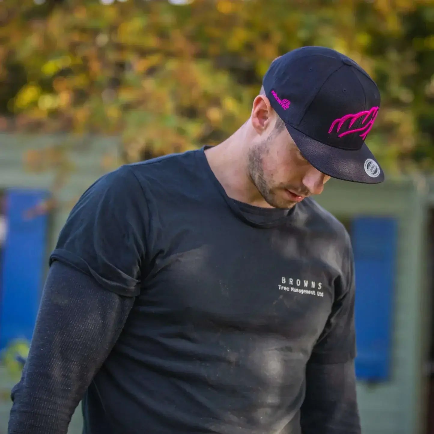 Tree surgeon wearing a stylish cap, showcasing Arborists' headwear for comfort and protection outdoors.