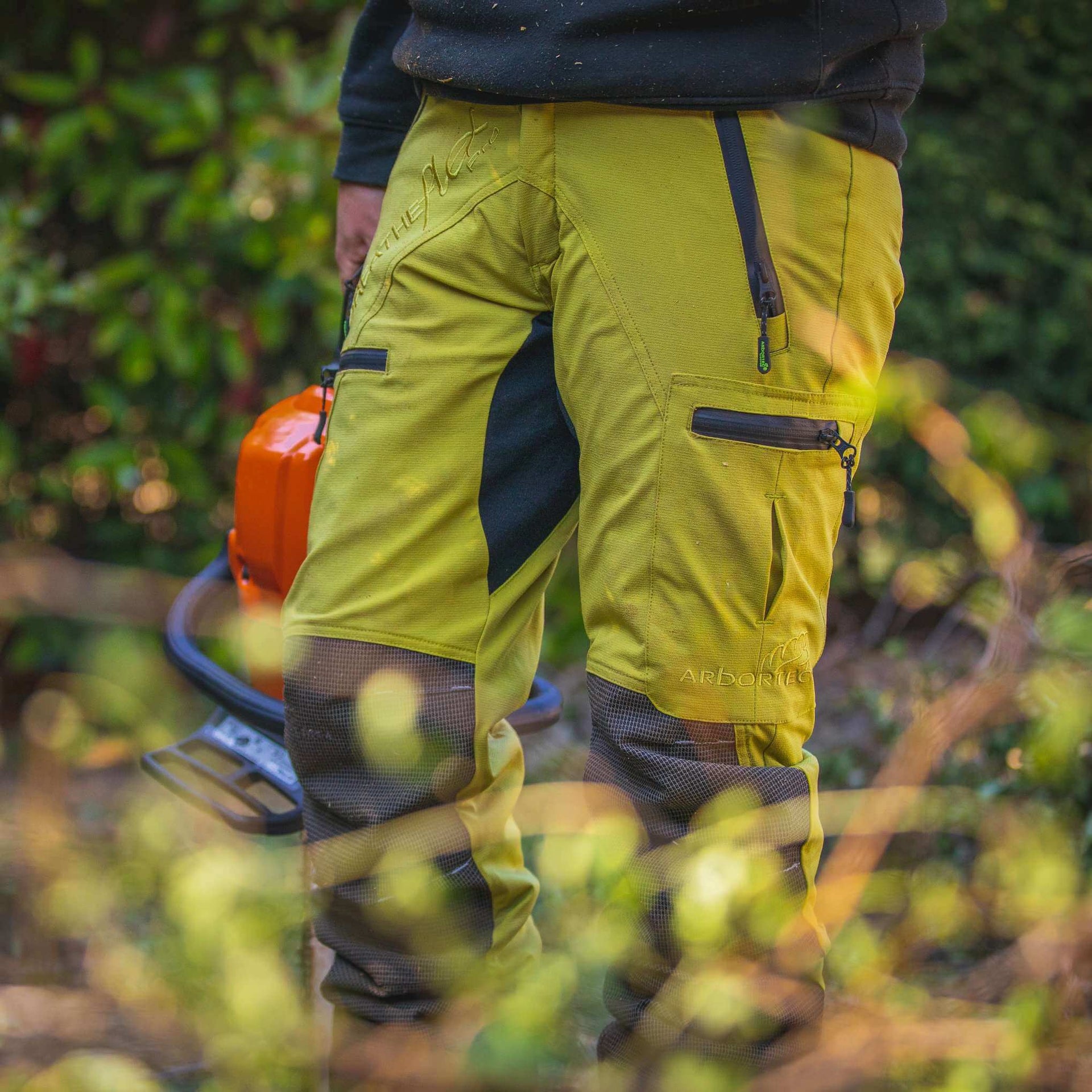 Arbortec Type C chainsaw trousers in vibrant yellow, designed for tree surgeons, providing safety and comfort.