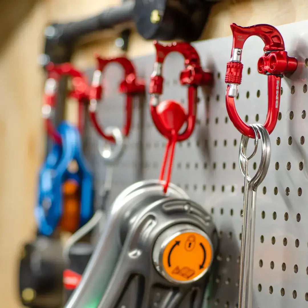 DMM karabiners displayed on a pegboard, showcasing high-quality gear for tree surgeons and outdoor enthusiasts.