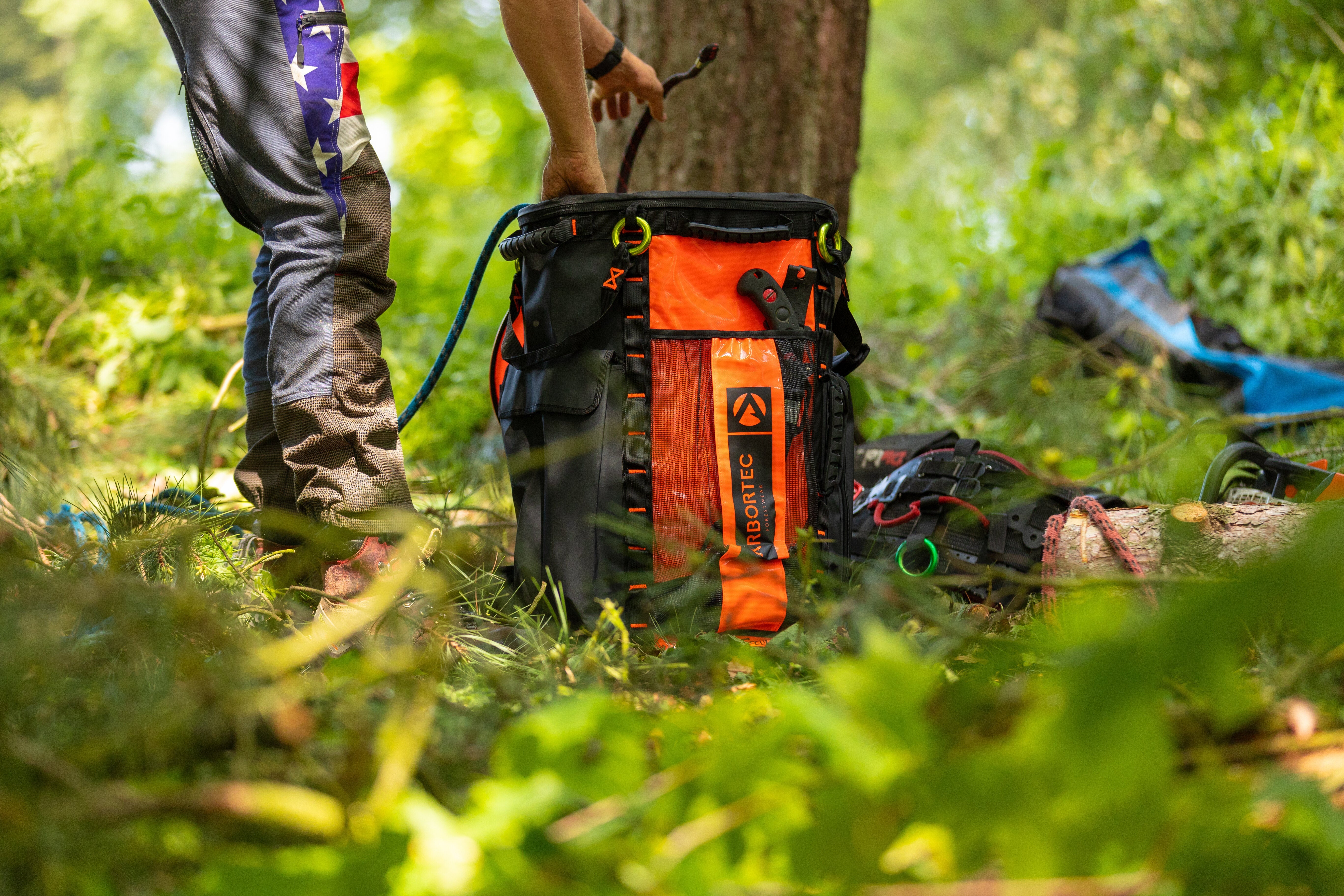 Arbortec Bags in use by a tree surgeon, showcasing durable storage for climbing equipment in a forest setting.
