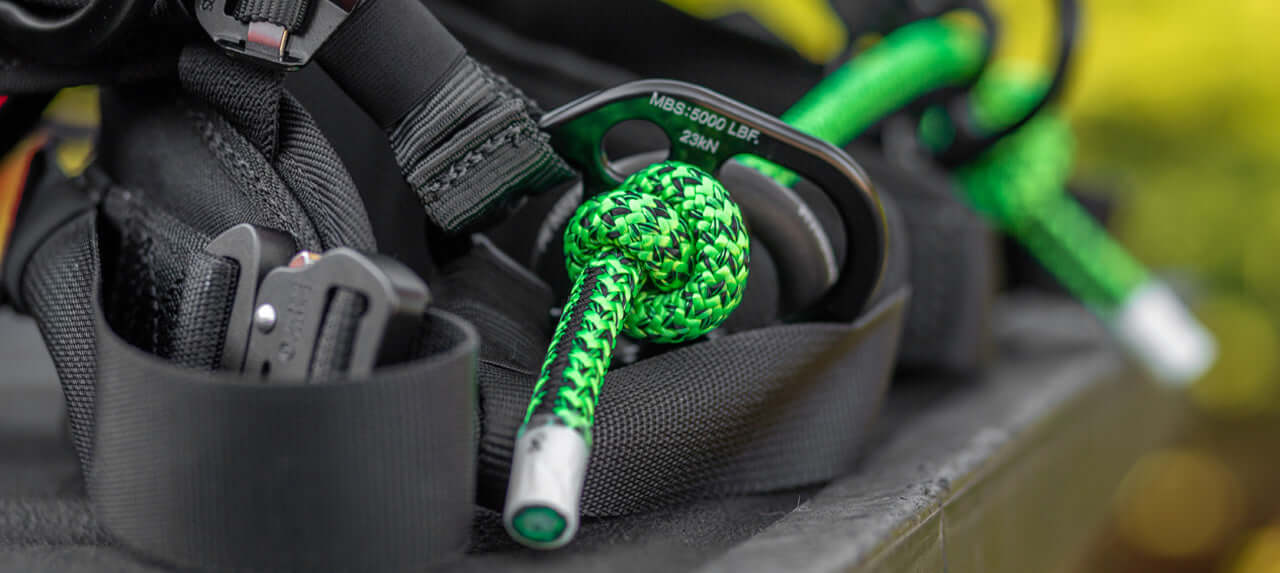 Close-up of harness equipment including green ropes used by tree surgeons for safe climbing and work.