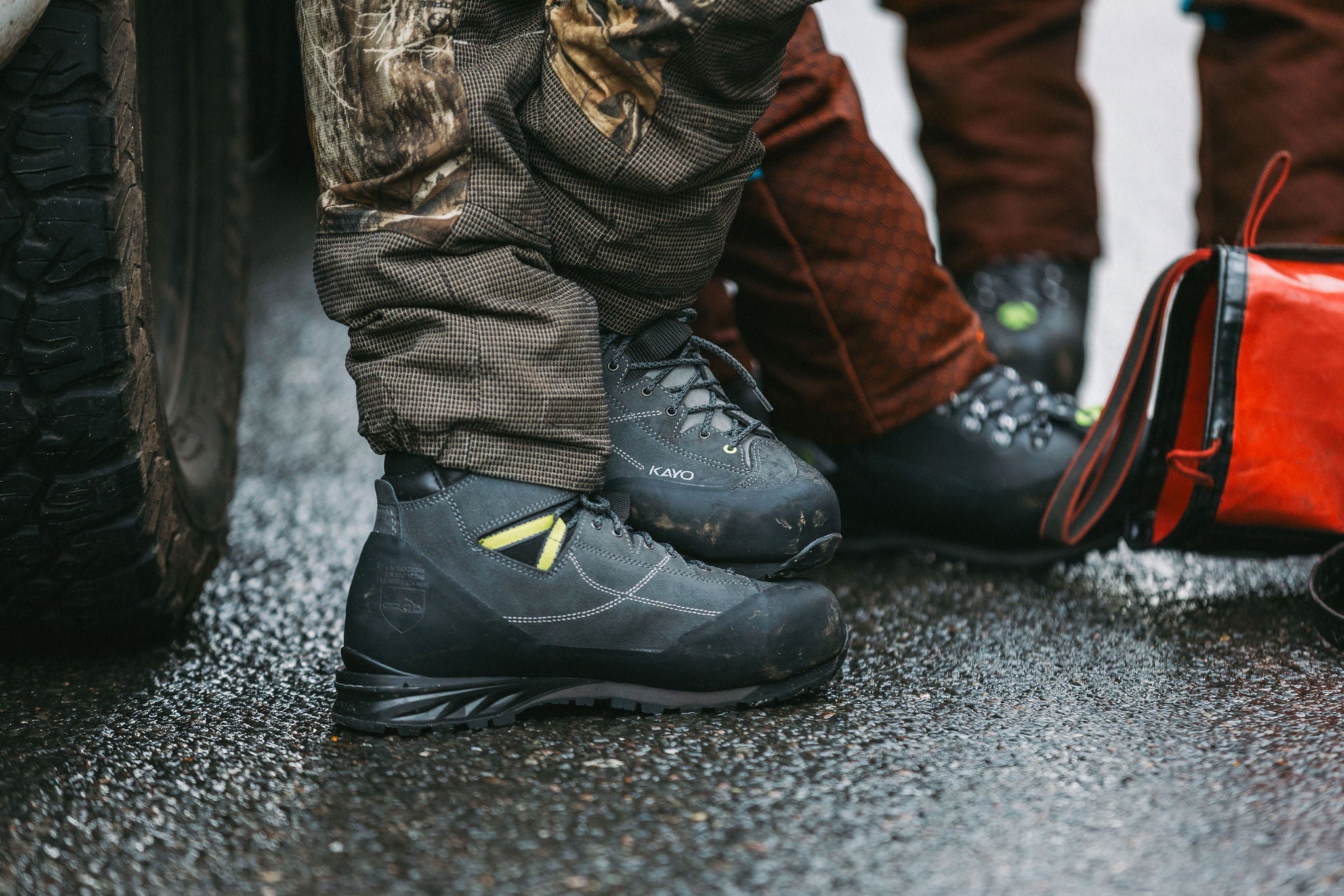A pair of Arbortec Kayo Chainsaw Boots worn by arborists on a wet surface, showcasing their durability and support.