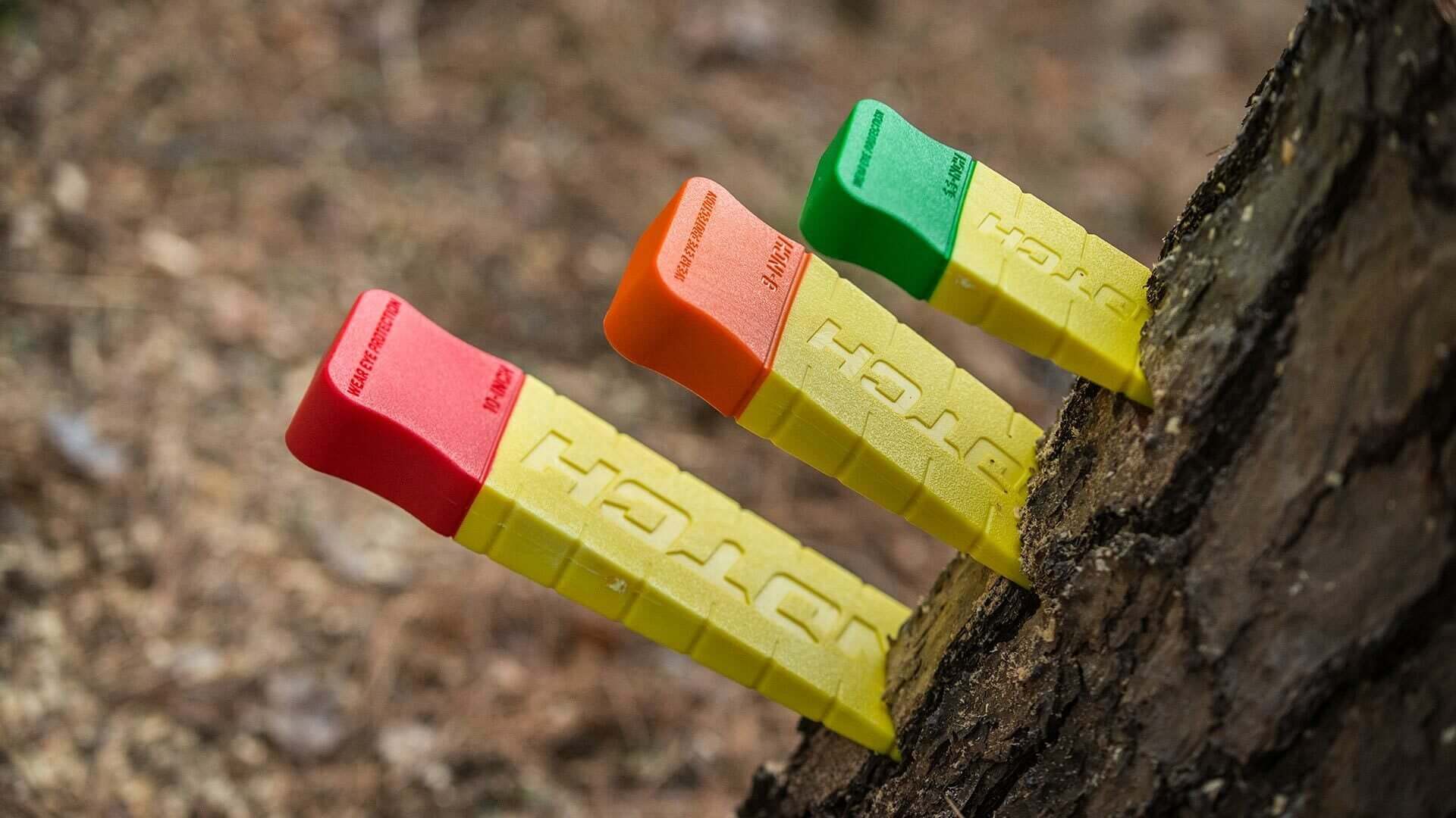 Notch forestry felling wedges in bright colors, used by tree surgeons for enhanced control and safety during tree felling.