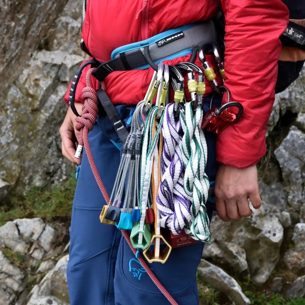 Climbing gear including rope and tape slings on a harness, essential for tree surgeons and climbing professionals.