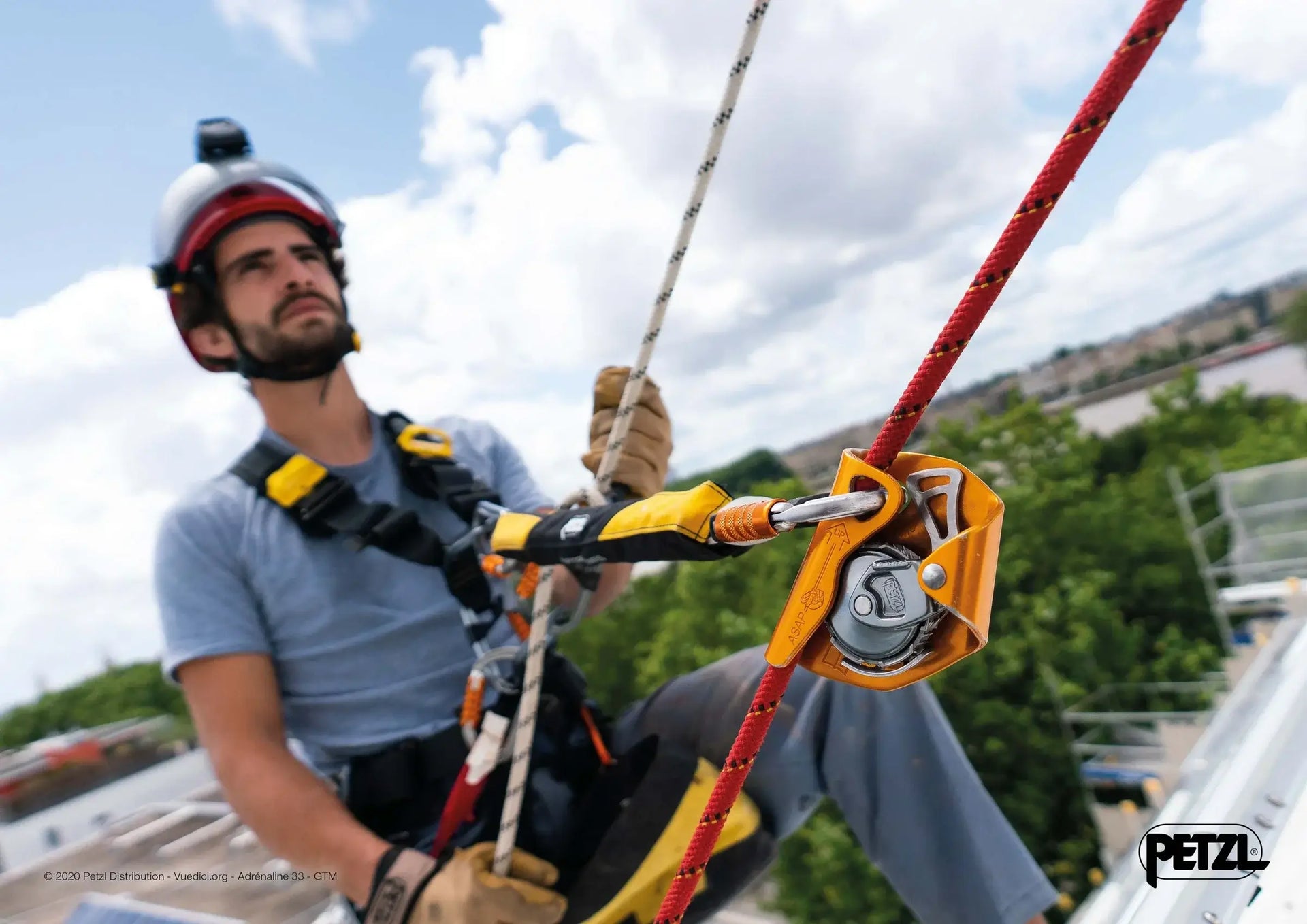 Tree surgeon using climbing equipment and a pulley system, demonstrating safe practices in rescue and tree work.