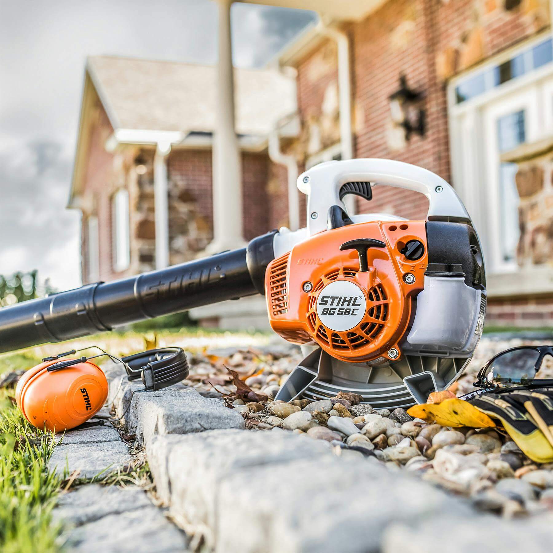 STIHL BG 56 CE petrol hand-held leaf blower on a stone path, ideal for garden maintenance and tree surgeons.