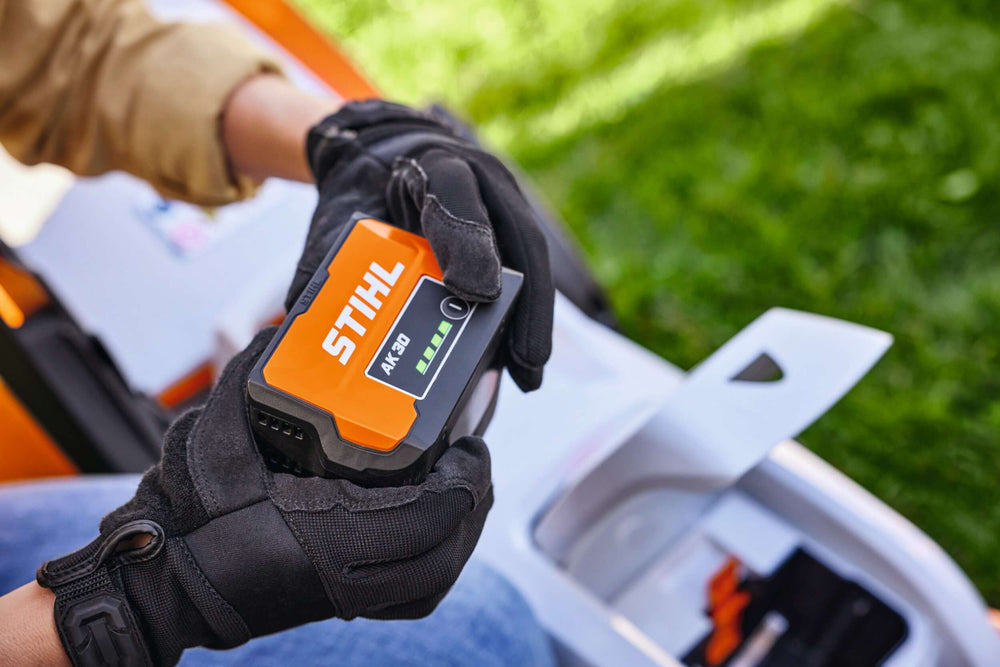 STIHL RMA 239 C Cordless Lawnmower battery being held, showcasing its 36 V lithium-ion power.