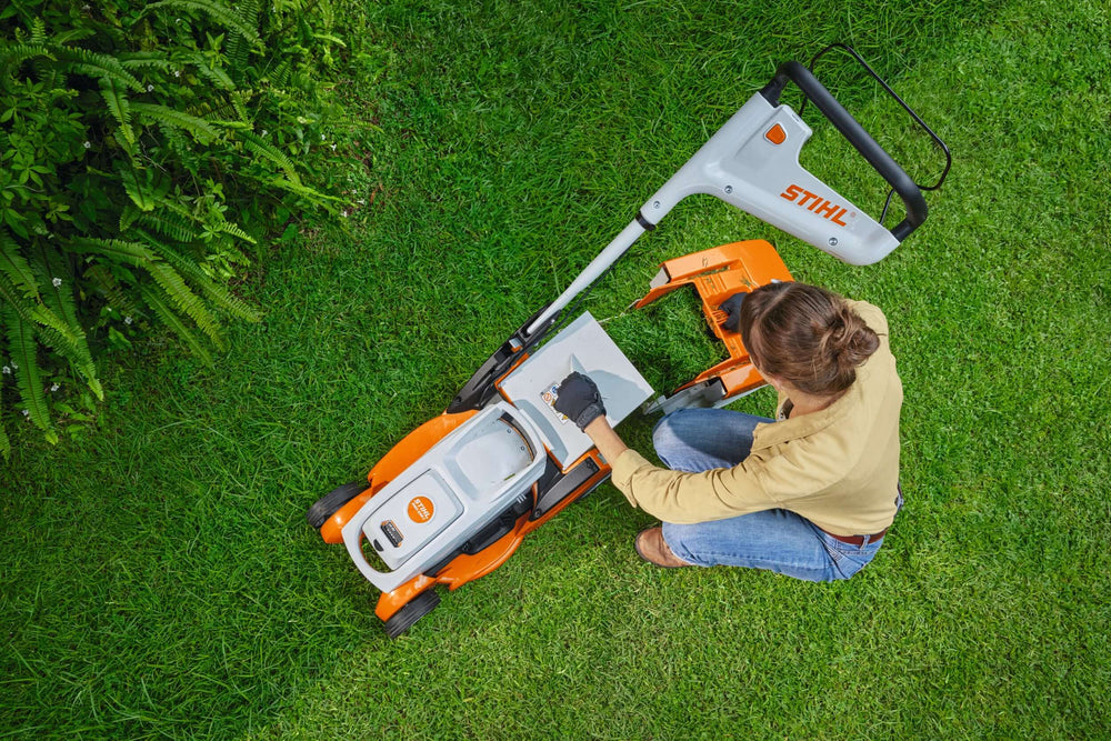 RMA 239 C Cordless Lawnmower being used by an operator on a grassy lawn.