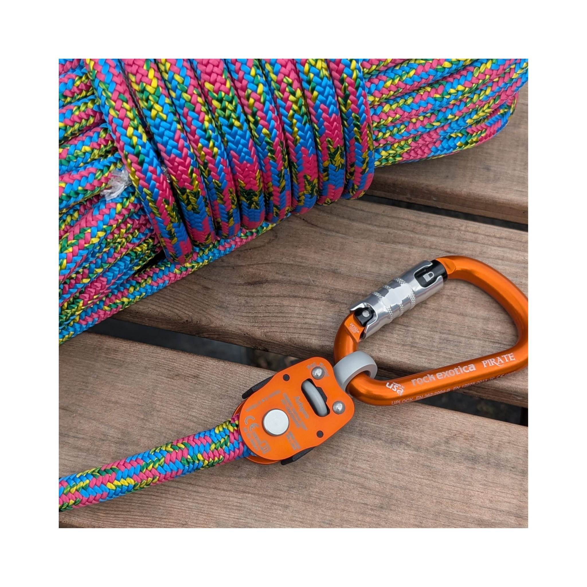 Omnix Swivel Eye&Pin connected to vibrant, multicolored climbing rope on wooden surface.