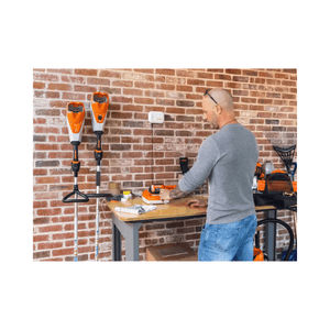 Tree surgeon working with STIHL equipment in a workshop, showcasing the AP 500 S Battery and tools.