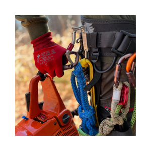 Close-up of a worker using a TransPorter XL Tool Karabiner on a chainsaw and climbing gear.