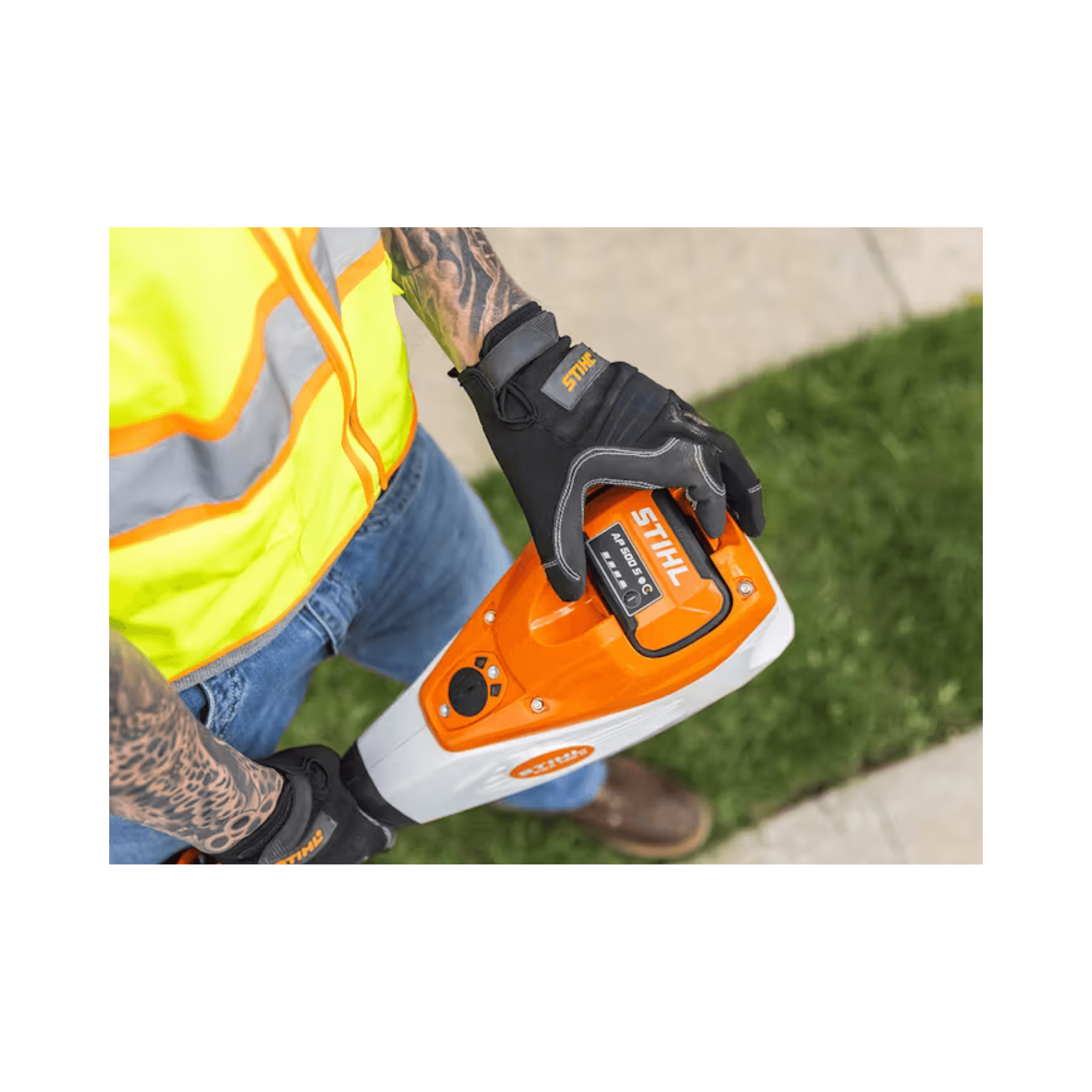 User holding a STIHL AP 500 S Battery while wearing safety gear, ideal for tree surgeons and professionals.