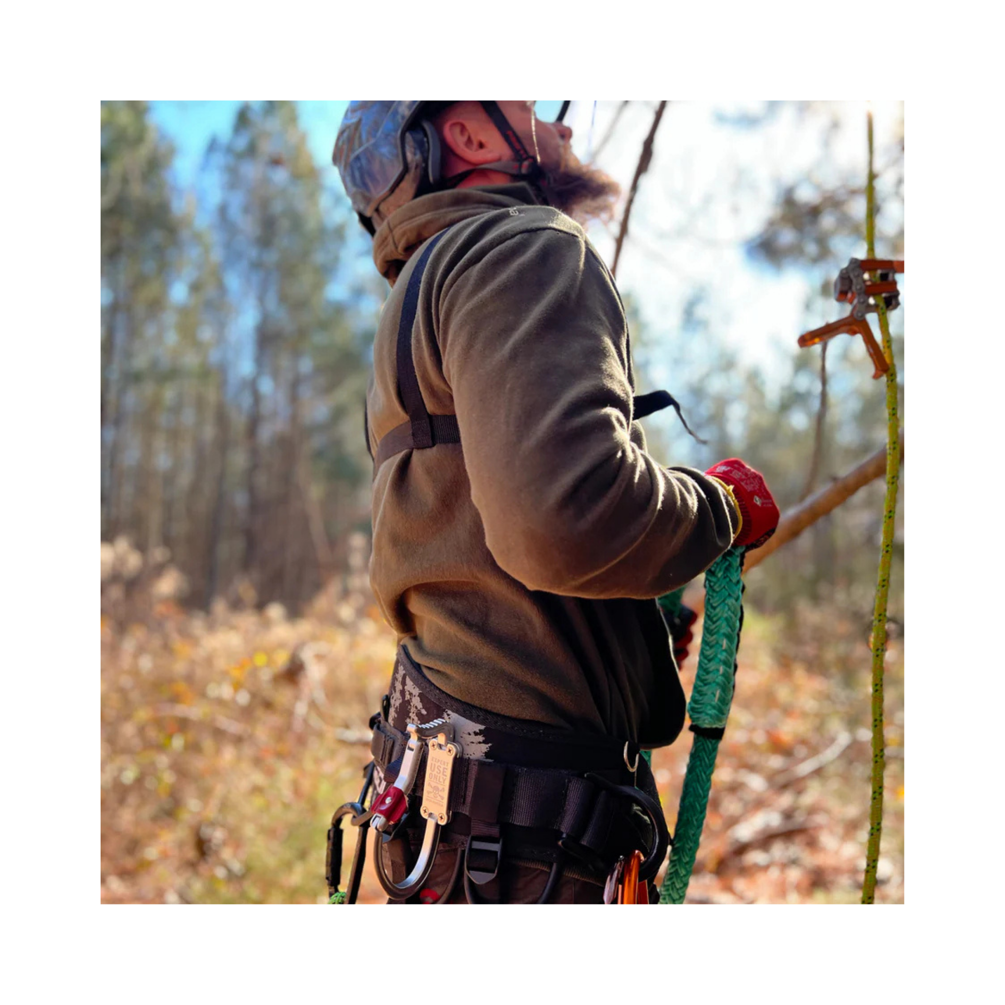Person using the TransPorter XL Tool Karabiner while climbing, showcasing harness and tools in an outdoor setting.