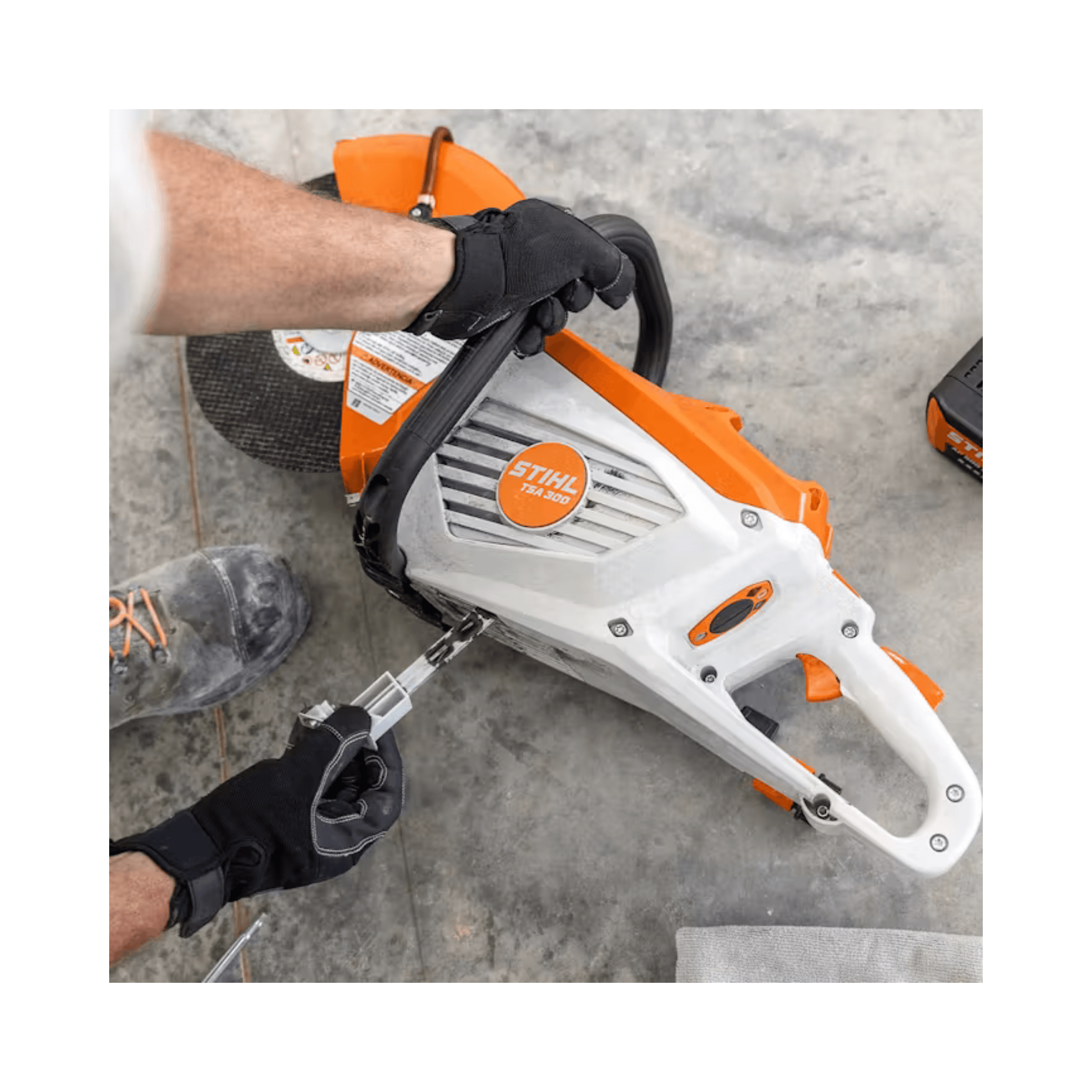 STIHL TSA 300 cordless cut-off machine with operator's hand, ideal for tree surgeons and hardscaping projects.