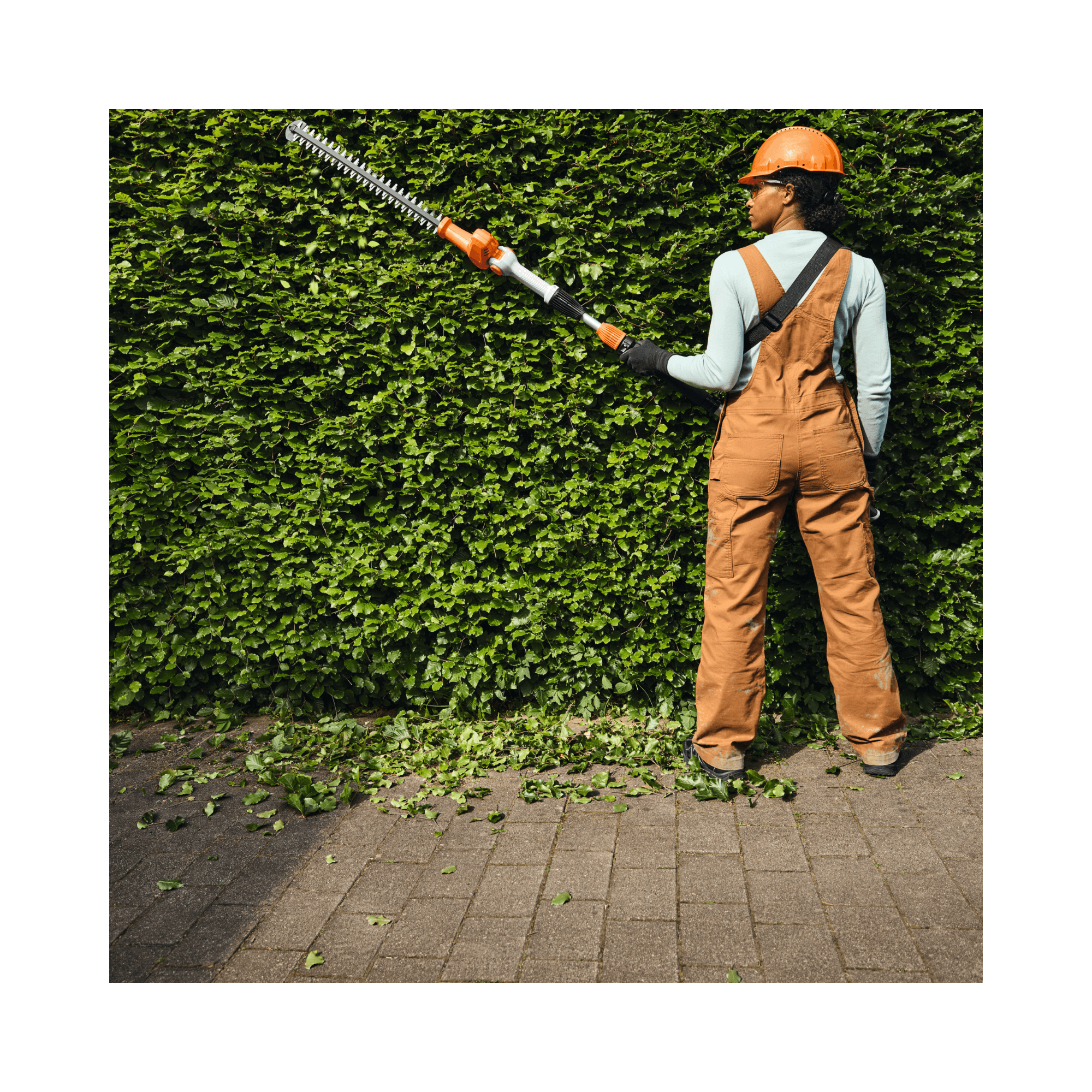 Person using HLA 40 Cordless Telescopic Long-Reach Hedge Trimmer for precise trimming, ideal for tree surgeons and arborists.