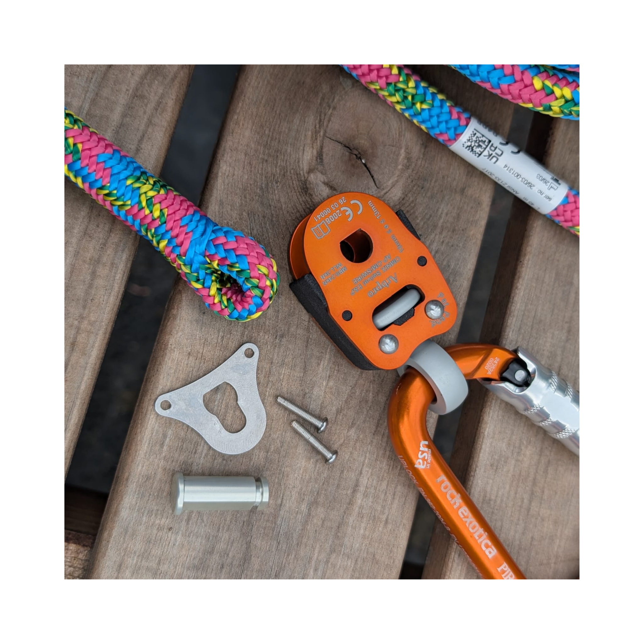 Omnix Swivel Eye&Pin with colorful ropes on wooden surface, showcasing climbing gear components.