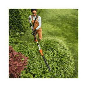 User using the HLA 40 Cordless Telescopic Long-Reach Hedge Trimmer for precise garden trimming.