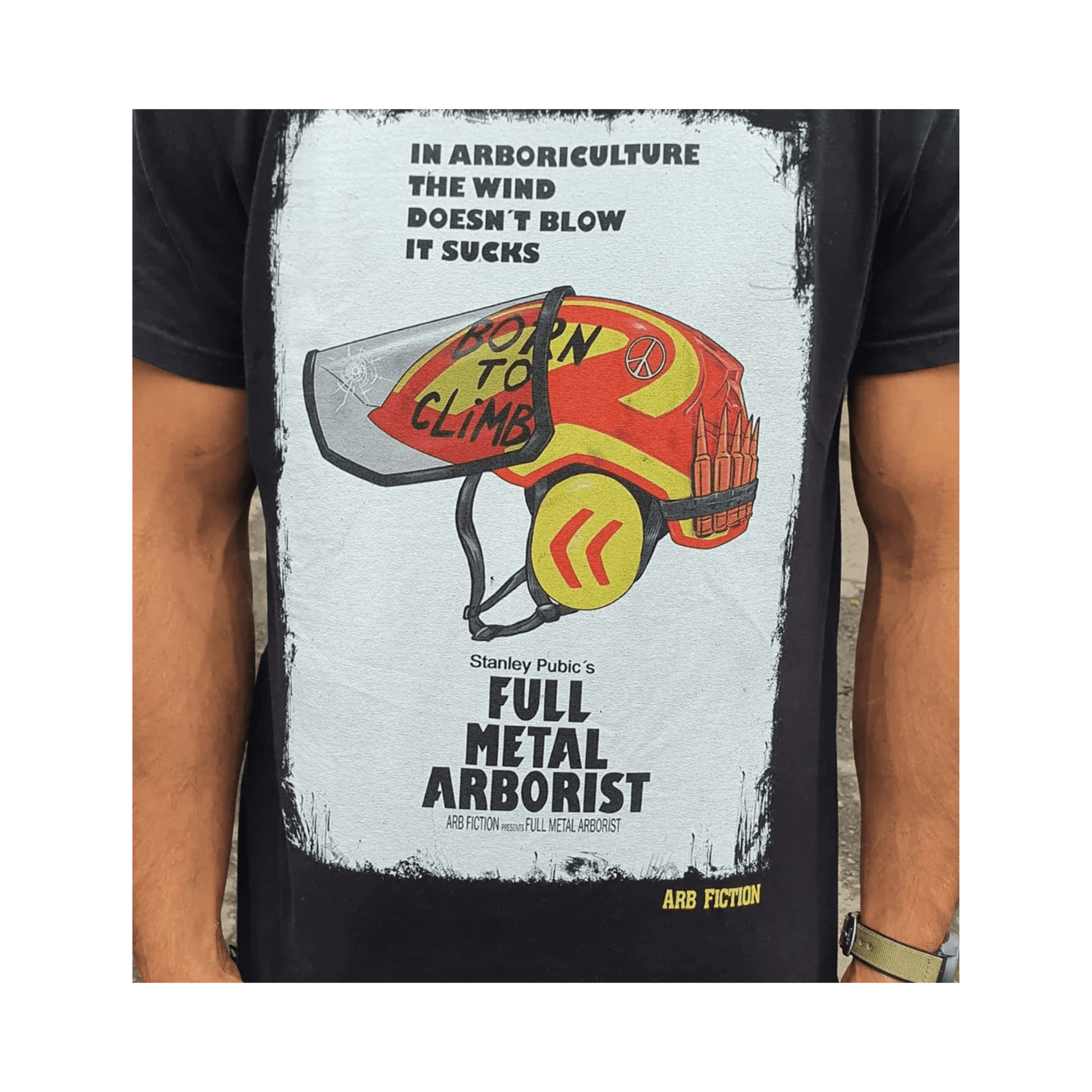 An individual wearing a Full Metal Arborist T-Shirt featuring a humorous graphic and arborist helmet design.