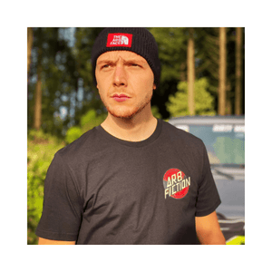 Man wearing Arb Fiction Screaming Hand T-Shirt in a forest setting, ideal for tree surgeons and outdoor enthusiasts.