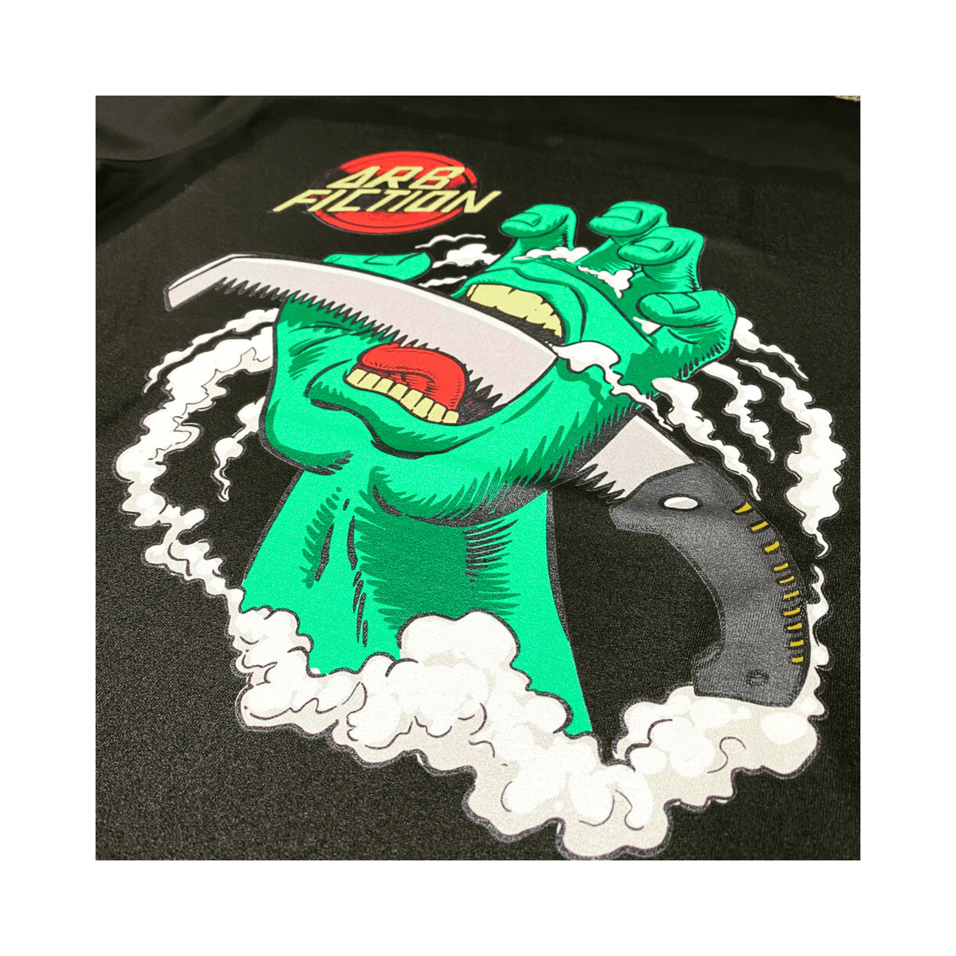 Arb Fiction Screaming Hand T-Shirt featuring a green hand holding a saw, perfect for Tree Surgeons and skateboard culture.