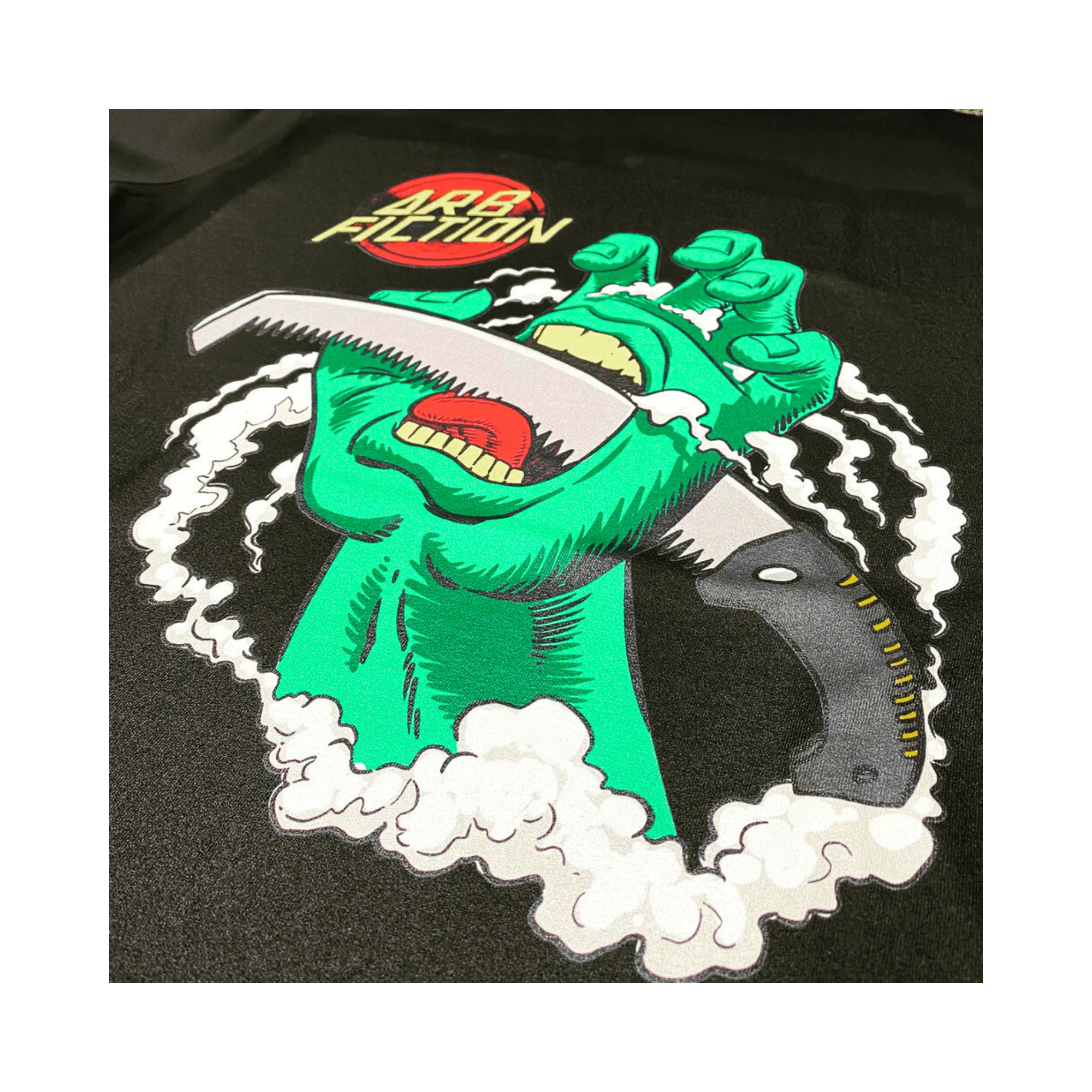 Arb Fiction Screaming Hand T-Shirt featuring a green hand holding a saw, perfect for Tree Surgeons and skateboard culture.