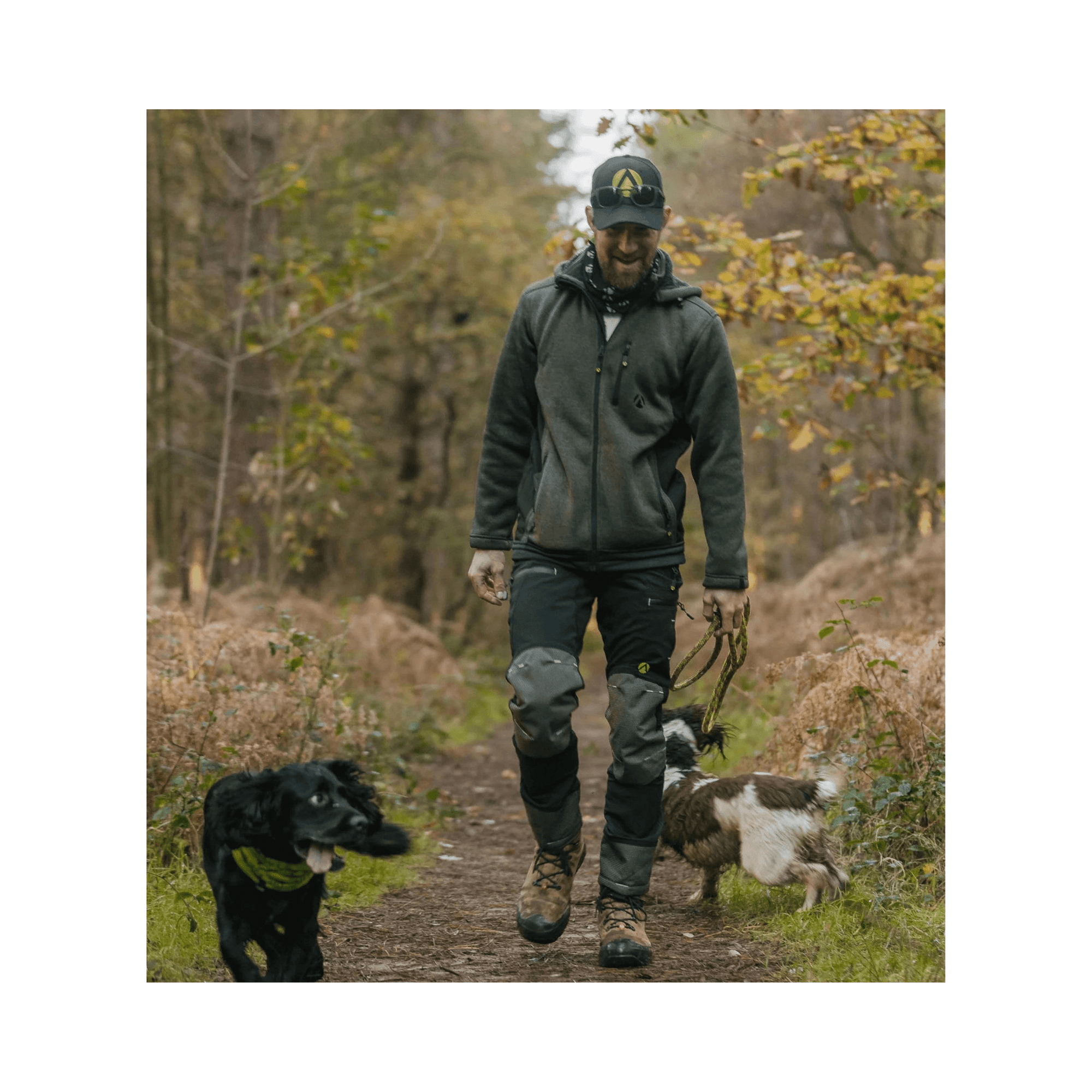 Person wearing Breatheflex Pro Trousers Non-Protective walking dogs in a forest setting.