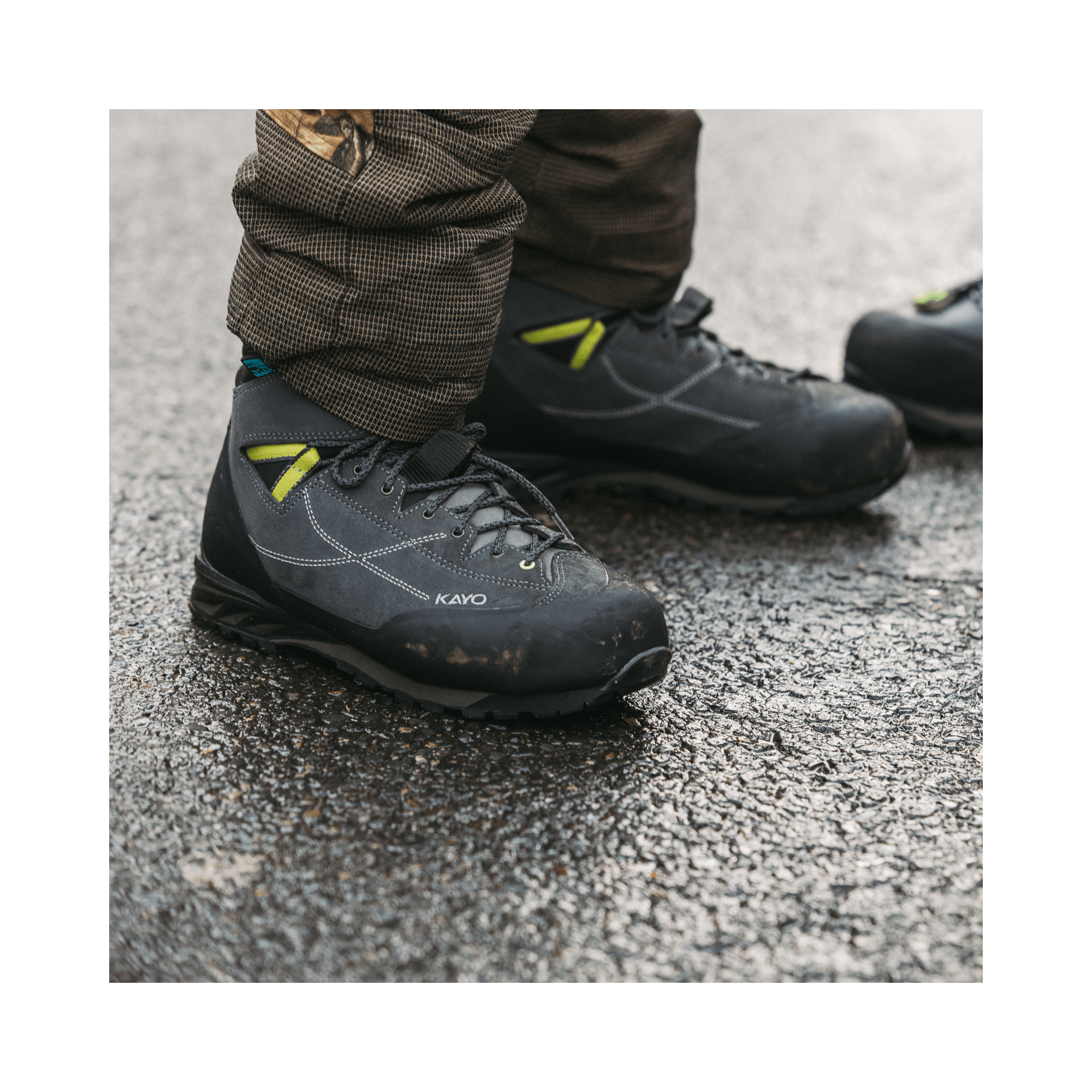 Kayo Chainsaw Boots Class 2 worn by a tree surgeon on a wet surface, showcasing protective features and modern design.