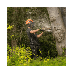 Tree surgeon using a chainsaw while wearing Arbortec Performance T-Shirt Short Sleeve outdoors.