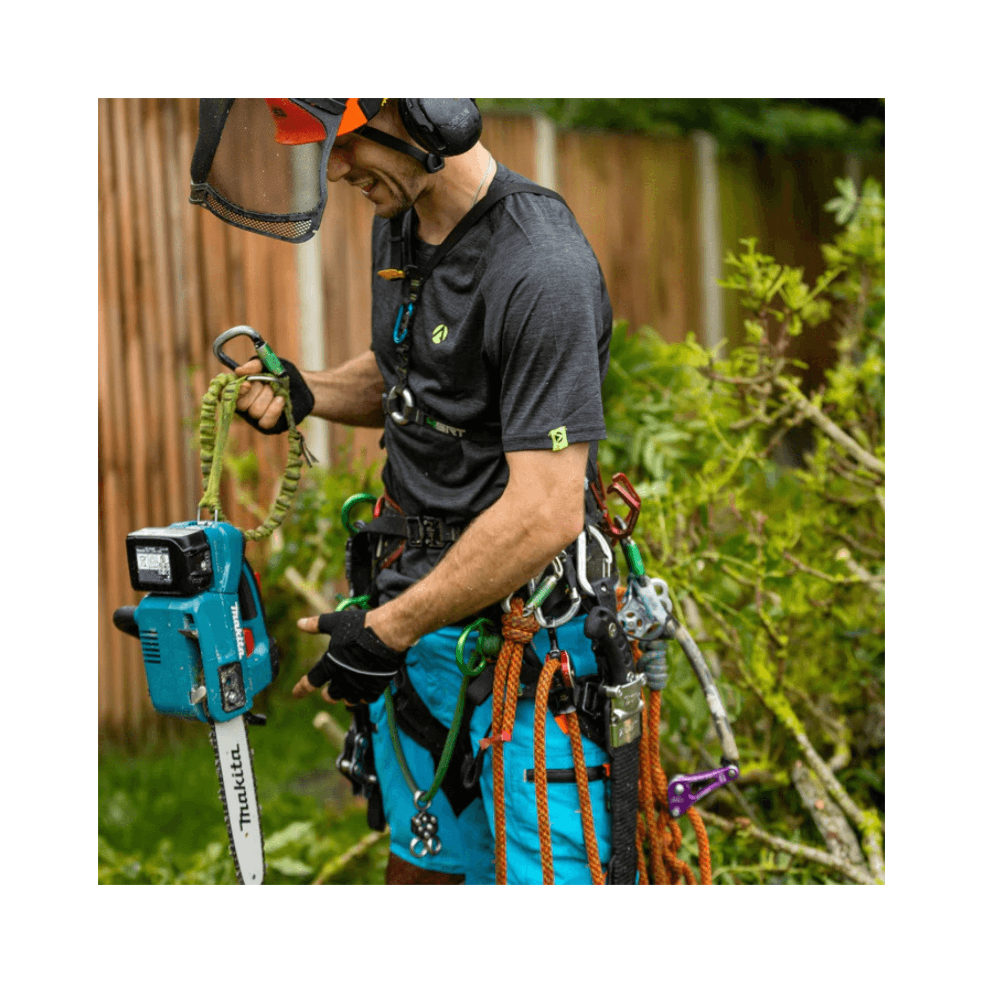 Tree surgeon wearing a Performance T-Shirt Short Sleeve while using an electric chainsaw in a garden.