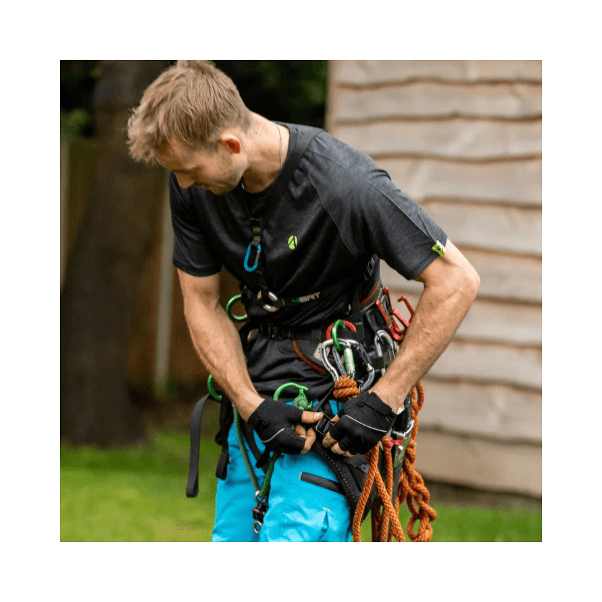 Man wearing Performance T-Shirt Short Sleeve while preparing climbing gear for tree surgery.