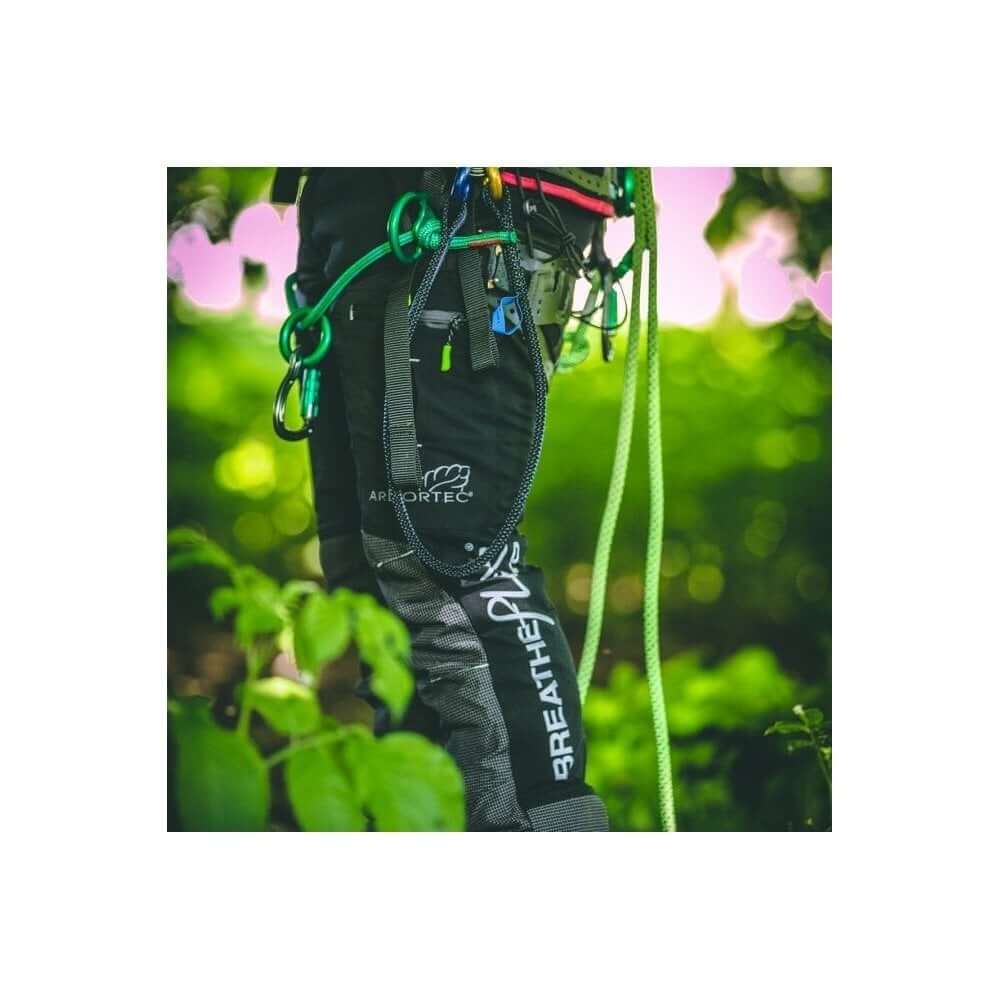 Arbortec Breatheflex Pro Chainsaw Trousers Black Type C worn by tree surgeon in green outdoor setting, showing agility and protection.