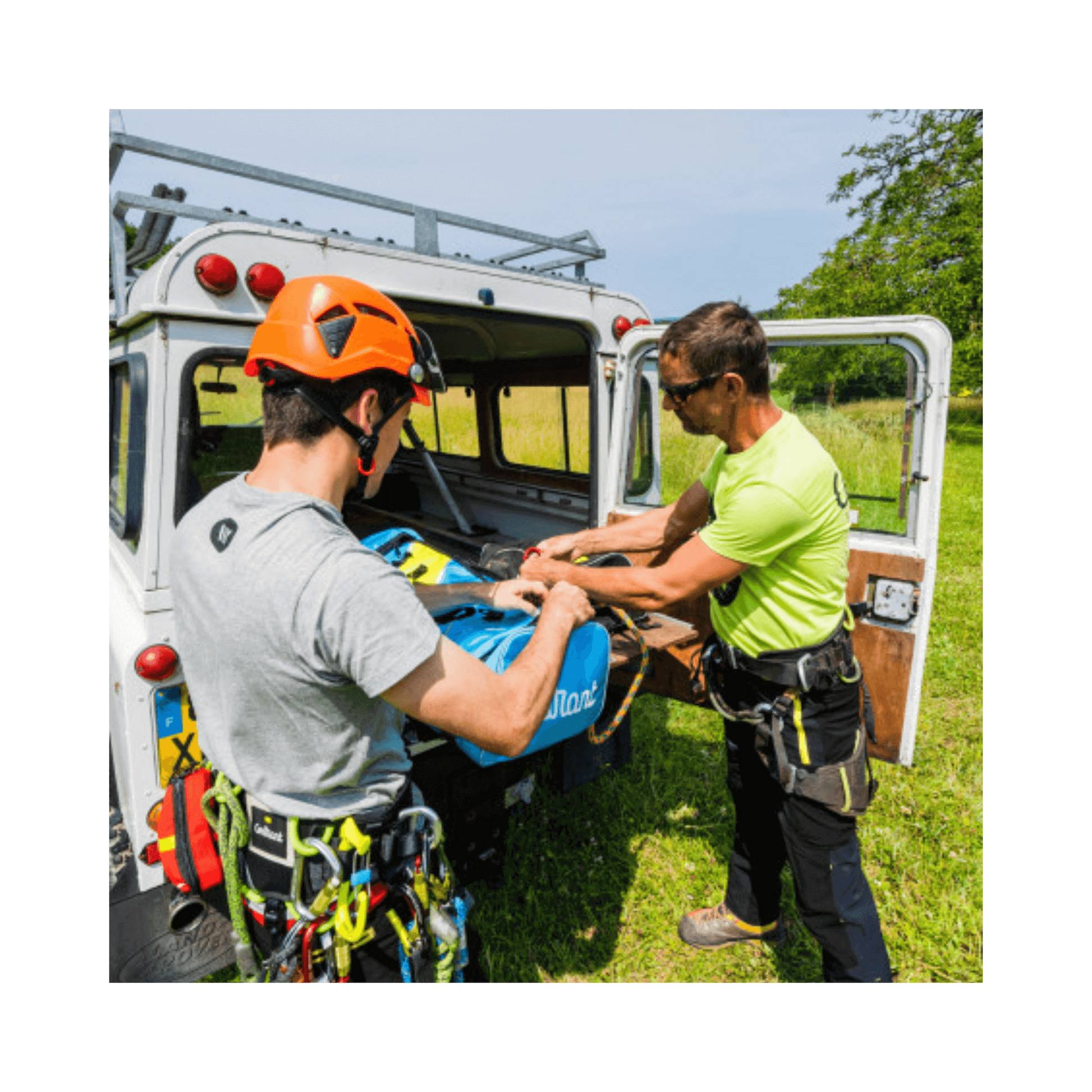 Two arborists preparing tools at a vehicle, showcasing the Honos Tool Carry Clip Small for climbing and tree care.