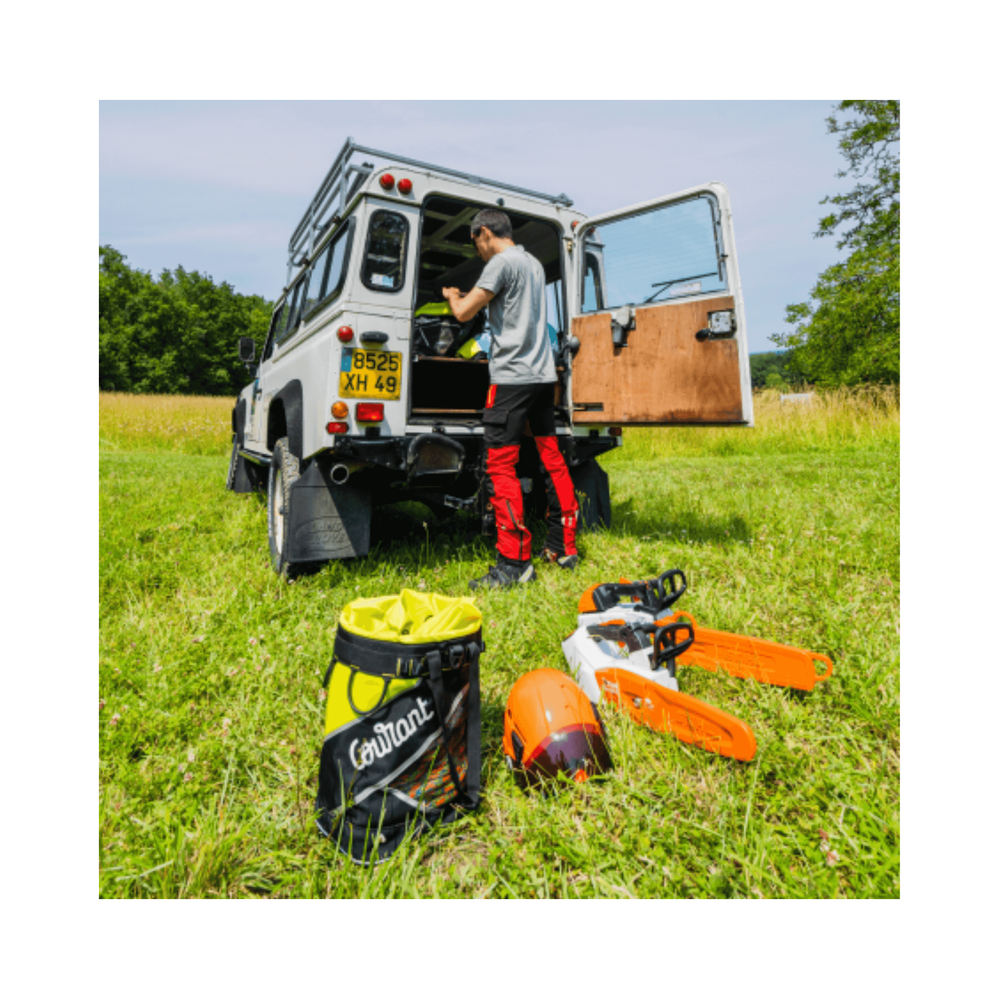 Person unloading the Courant Host Rope Bag and chainsaws from a vehicle in an outdoor setting.
