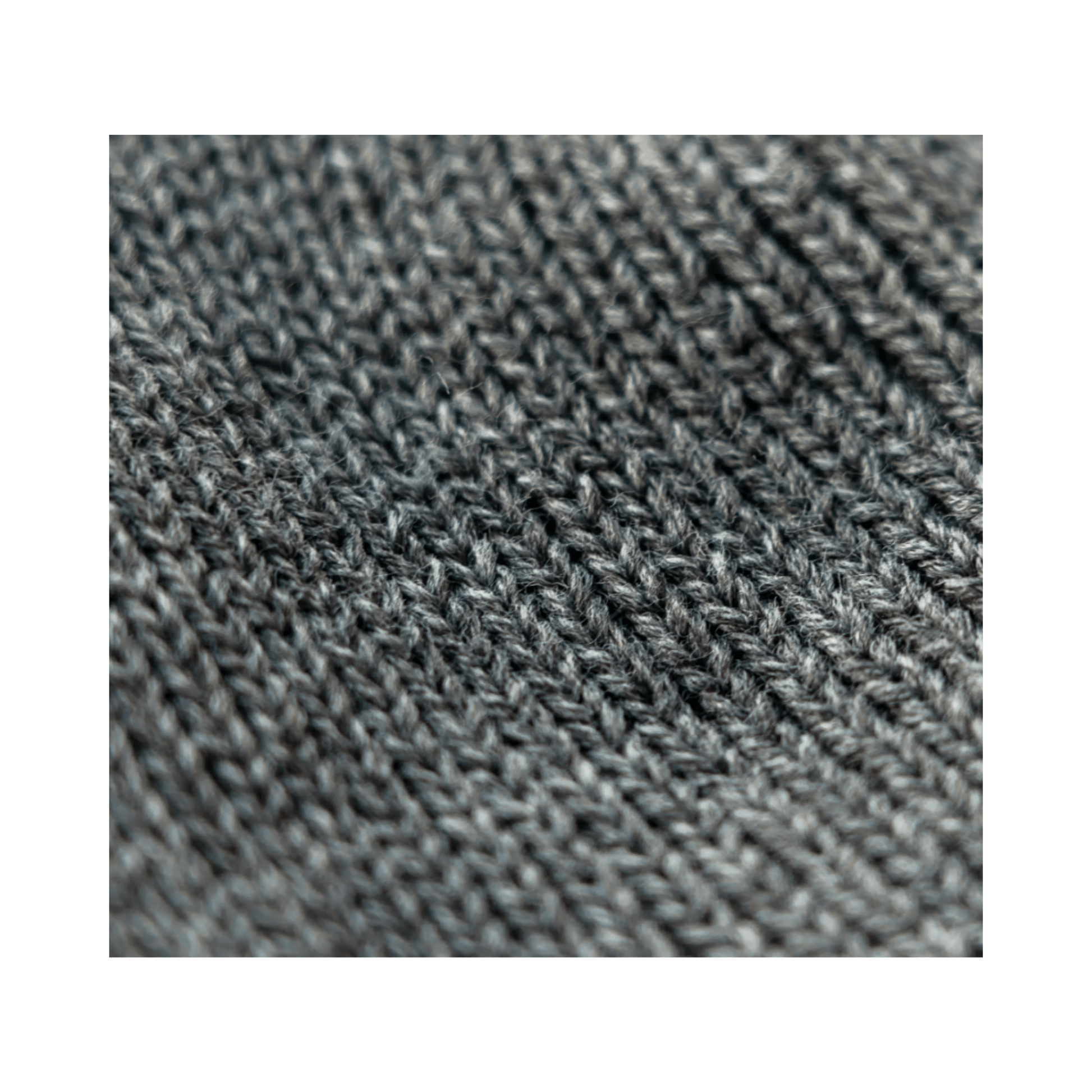 Close-up of the knitted fabric of the Heritage Beanie in mid-grey, showcasing its soft texture for climbers and tree surgeons.