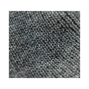 Close-up of the knitted fabric of the Heritage Beanie in mid-grey, showcasing its soft texture for climbers and tree surgeons.