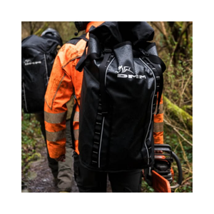 DMM Porter Rope Bag worn by professionals on a rainy outdoor trail, showcasing its durability and high-capacity design.
