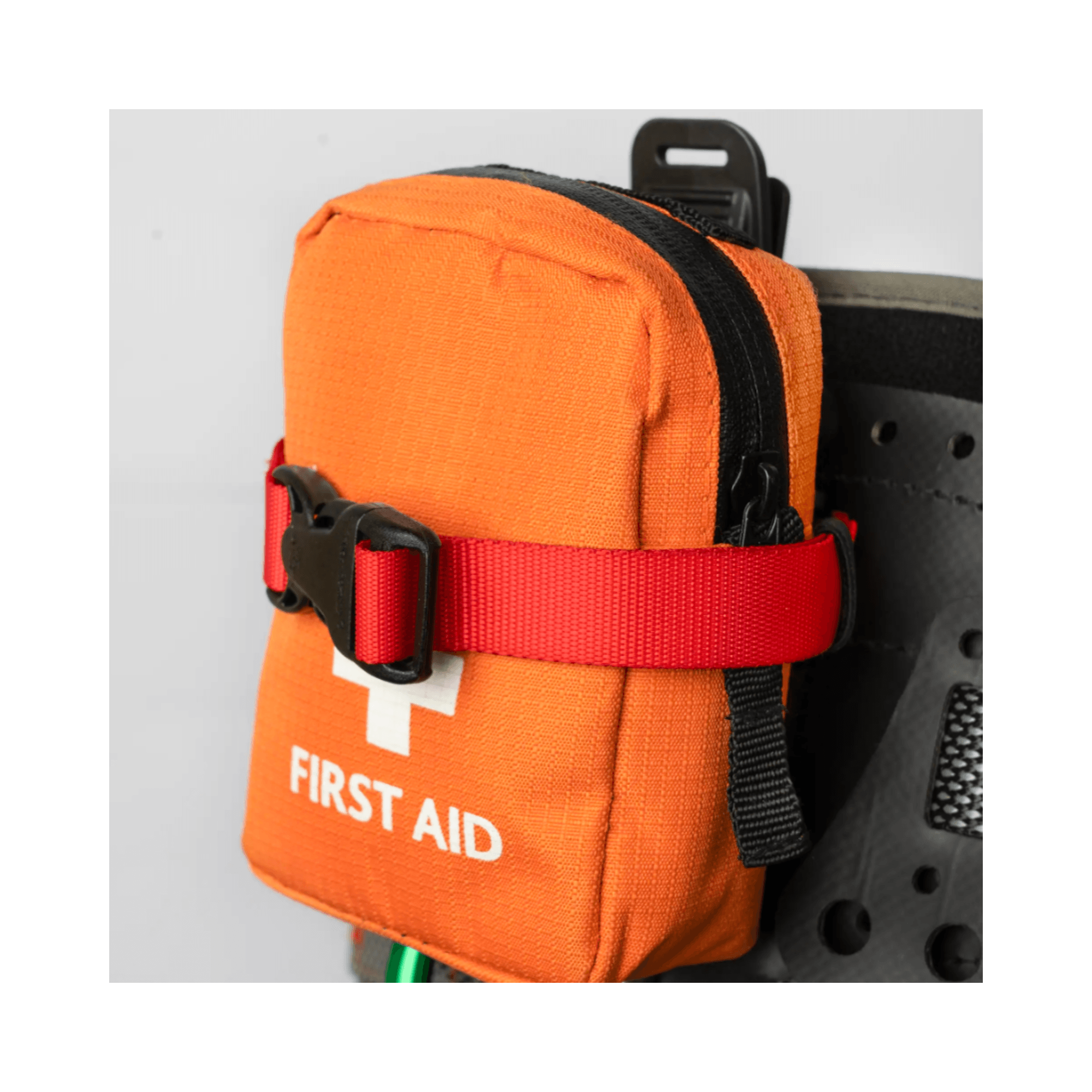 Caiman Harness Strap securing an orange first aid pouch for easy access and safety at height.