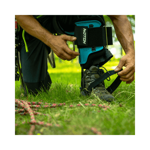 Person wearing Steel Climbers while securing a strap, showcasing ergonomic design and comfort.