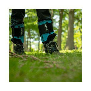 Pair of Notch Equipment Ergo Steel Climbers worn by an arborist on grassy ground.