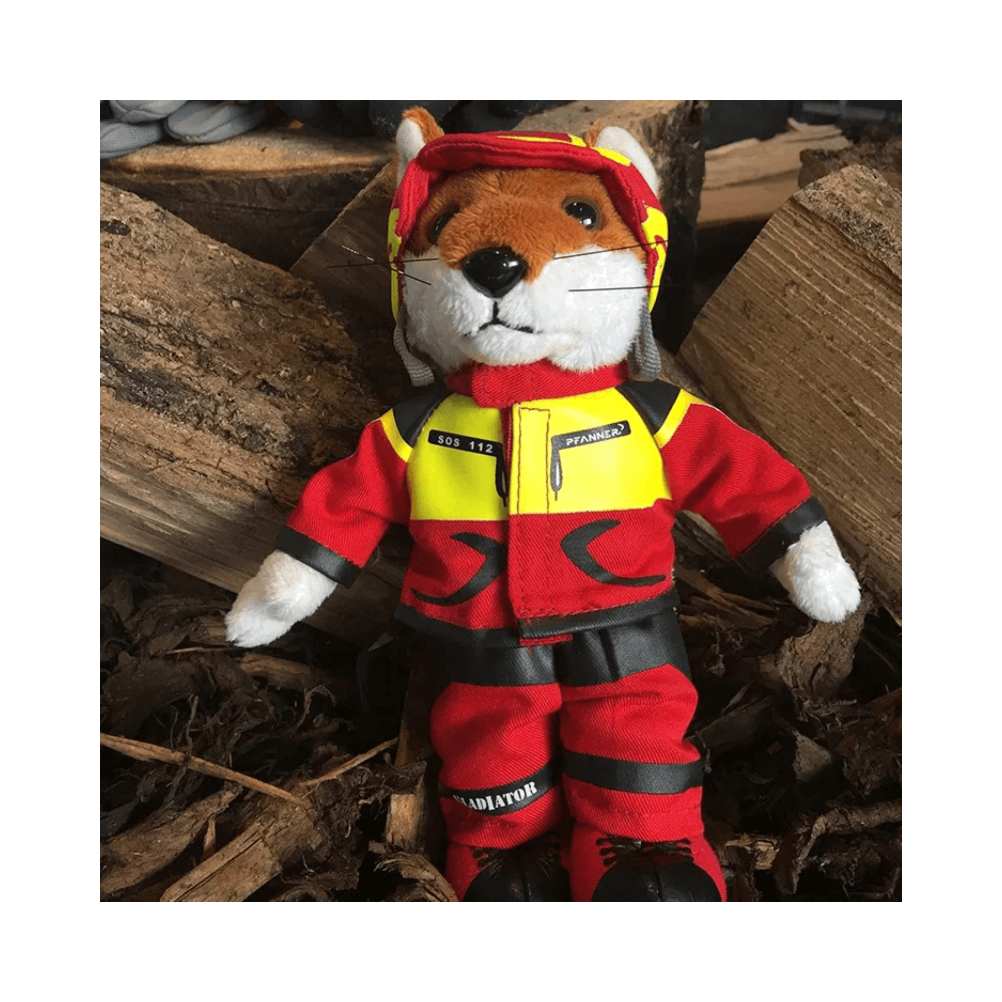 Plush toy fox in firefighter gear on a wooden background